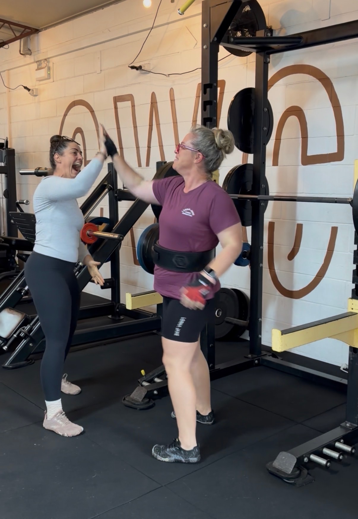 Julie celebrating a personal best lift with Kellie at the gym
